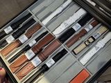 a person holding a case full of different types of watches
