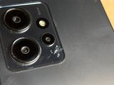 the back of a person holding a black phone with three cameras on it