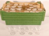 bottles and glasses in a wooden box on a white surface