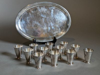 a lot of silver cups and a silver tray on a table