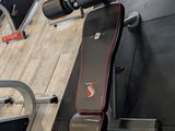 a gym room with a row of exercise equipment on the floor