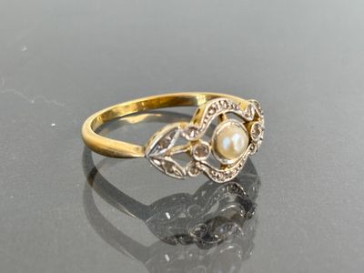 an image of a pearl and diamond ring on a table