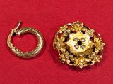 une broche en or et une bague en or sur un fond rouge