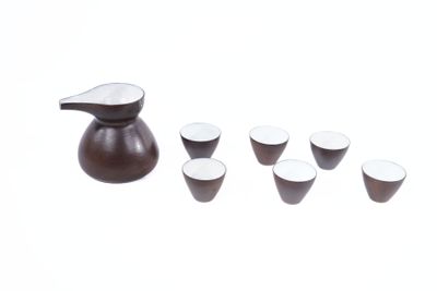 un pichet et des tasses posés côte à côte sur une table
