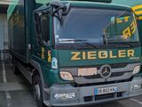 a green truck that is parked in front of a building