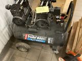 un petit compresseur d'air posé sur le sol d'une pièce