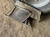 a tire that is sitting on the ground next to a piece of metal