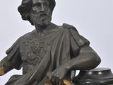 a statue of a man sitting on top of a clock