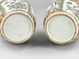 pair of chinese vases with floral designs on them on a gray surface