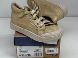gold leather sneakers with laces on top of a cardboard box