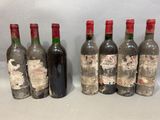 six bottles of wine are lined up in a row on a table
