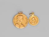 a close up of a gold medal and a coin on a gray surface