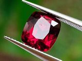 un gros plan d'un diamant rouge tenu par une pince