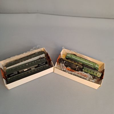 two boxes with different types of toy trains in them