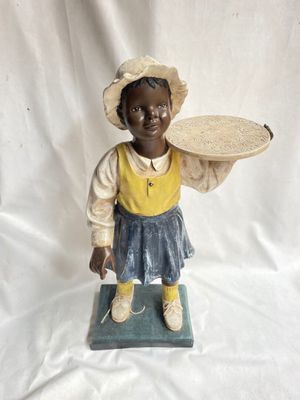 figurine représentant une petite fille avec un chapeau et un panier sur la tête