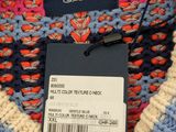 a close up of a sweater with a tag on it