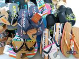 many pairs of flip flops that are on a table