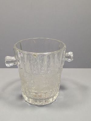 un verre en verre transparent muni d'une anse, posé sur une table