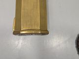 a gold lighter sitting on a table next to a mirror