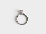 a close up of a diamond ring on a white surface