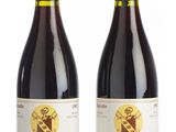 two bottles of wine sitting next to each other on a white surface
