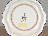 a white plate with a flower on it on a table