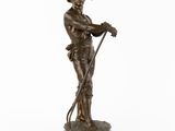 une statue en bronze représentant un homme muni d'une canne et portant un chapeau