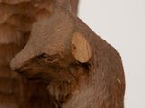 a carved bear that is sitting on a tree stump