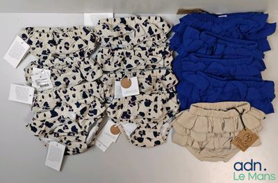 two pairs of baby diapers and a diaper cover on a table