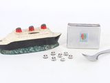un petit bateau miniature avec une cuillère et un repose-cuillère à côté