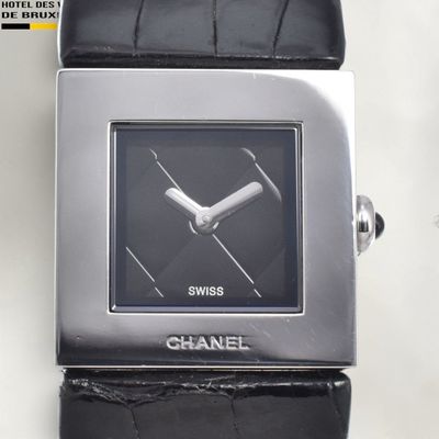 a black watch with a silver face on a black leather strap