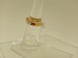 un support en verre transparent surmonté d'un anneau doré