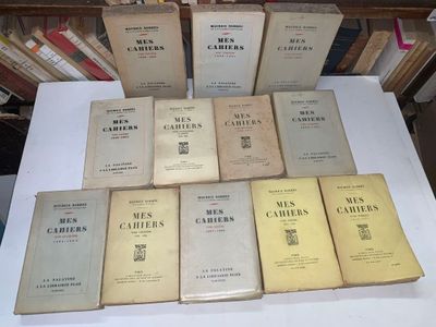 des livres posés sur une table dans une pièce où il y a beaucoup de livres