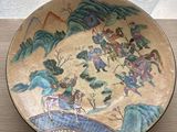 a plate with a painting on it sitting on a table