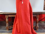 a red cloak sitting on the floor in front of a table