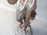 a statue of a woman holding a bag and a purse