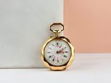 gold pocket watch with roman numerals on a marble block