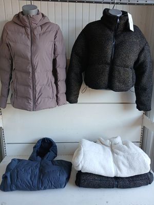 deux manteaux suspendus à un portant dans un magasin de vêtements