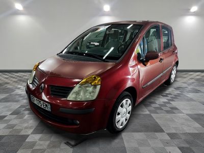 une petite voiture rouge garée dans une pièce