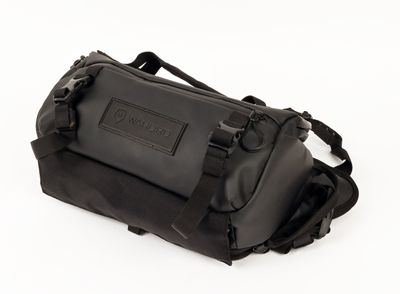 the back of a black duffel bag on a white surface