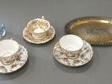 three cups and saucers on a table with a tray