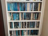 a book shelf with many books on it in a room