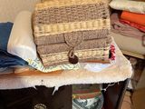 a basket sitting on top of a table next to a pile of clothes