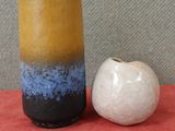 deux vases posés l'un à côté de l'autre sur une surface rouge