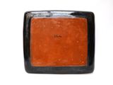 an image of a black and orange plate on a white surface