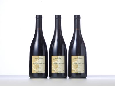 three bottles of wine are lined up on a table