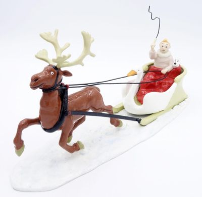 figurine représentant un renne tirant un traîneau sur lequel se trouve le Père Noël