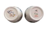 pair of white ceramic vases with colorful designs on them