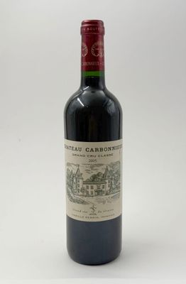 une bouteille de vin rouge posée sur une table blanche