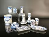 many blue and white dishes and cups on a black table